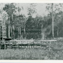 Detailed inscription on the back of photograph handwritten by John Lundy-Clarke. Child Bros sawmill in its very first days under steam. The water race or flume comes from the right just at tops of bushes to the redundant water wheel out of picture left. About 1903.