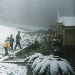 The first Mount Dandenong State School opened in a shed on the property of William Ferguson on the corner of Blythe and Old Coach Roads. The first teacher was Miss Ethel Gruber who opened the school on May 11th, 1897. It wasnt until 1901 that the school shifted over the road into an old school building that was moved up to the new site from Ringwood. All the buildings were demolished to make way for a new school that opened in 1991. Up until the later 2000s snow fell at the school several times a year.: Three children playing in snow at the front of Mount Dandenong Primary School 5th September 1995. The snow lasted three days.