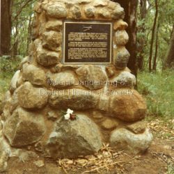 Cairn commemorating the crash of the aircraft Kyeema on the western slope of Mt Dandenong on October 25th, 1938. Photograph taken in 1988. Text on plaque reads: FIFTY METRES BELOW THIS POINT ON 25 OCT. 1938, AUSTRALIAN NATIONAL AIRWAYS' DC-2 'KYEEMA' PLUNGED TO DESTRUCTION WHILE THE MOUNTAIN WAS ENVELOPED IN CLOUD. ALL 18 PERSONS ON BOARD PERISHED. FROM THE RECOMMENDATIONS OF THE SUBSEQUENT ENQUIRY HAVE EVOLVED THE AIR TRAFFIC CONTROL SYSTEMS IN USE THROUGHOUT AUSTRALIA TODAY. THIS PLAQUE, PLACED BY THE MOUNT DANDENONG HISTORICAL SOCIETY, WITH ASSISTANCE FROM G. GRAMP & SONS, THOS. HARDY & SONS, S. SMITH & SON, AUSTRALIAN FEDERATION OF AIR PILOTS AND FORESTS COMMISSION OF VICTORIA, WAS UNVEILED ON 25TH OCT. 1978 TO MARK THE 40TH ANNIVERSARY OF THE DISASTER.