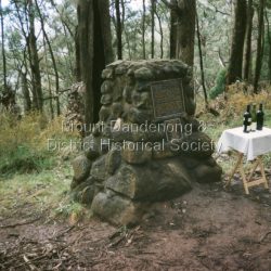 The cairn commemorating the Kyeema aircraft disaster with the addition of a smaller plaque listing the names of those who perished in the accident. This additional plaque was suggested by relatives of the victims who had attended earlier commemorations of the accident at the site. Mt Dandenong & District Historical Society members observed a minute's silence and drank a toast of South Australian wine, produced by vineyards with which some of the victims were associated, in memory of all those who lost their lives. The plaque reads: KKyeema VH-UYC Crew And Passengers Captain Alfred Webb Junior Captain Allan Steen Air Hostess Alva Jones Cadet Pilot Philip Pring Leonard Abrahams K.C. Alfred Gain Hans Gloe Stella Gloe Gordon Goddard Hugo Gramp Thomas Hardy Charles Hawker M.H.R. George Ling James Massie Vaughan Pate Elizabeth Schrader Lancelot Shirley Sidney Hill Smith