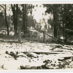 Snow on the ground at Mount Dandenong in September 1938 with the Mount Dandenong School House in the centre of picture behind fence.: On back of photograph: School House Mount Dandenong Sep. 1938.