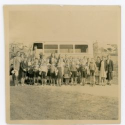 Mount Dandenong School pupils & Swimming Bus. Pupils from Mount Dandenong State School lined up in front of bus that will take them to a swimming lesson at Lilydale Baths. Mr M Morris, Headmaster, on the left. Taken in 1938.: On back of photograph: Pupils with M. Morris of Mount Dandenong School going to Lilydale Baths for swimming lessons. 1938?