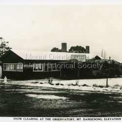 Snow scene showing the Observatory, Mount Dandenong, elevation 2077 feet. Tea rooms and a snowman