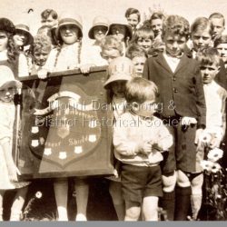Young students from St Matthew's Sunday School, Olinda holding the Sunday School Shield. C 1935. The pictured shield is kept in the St Matthew's Church Hall. From the back L - R. ?, Jean Patterson, Peggy Hall, Roy Breen, Mona Griffin, ?, Gwen Evans, Douglas Hall, Bill Brown, Keith Evans, Stewart Brown, Jack Breen, Ian Ellis, ?, ?, ?, Jeff Evans, Russell Hall, ?, ?, John Miles, Frank Boulter, Joan Boulter, Geoff Miles, Joan Bartlett, Nan Breen, Thomas Hall.