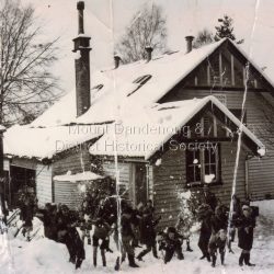 The photograph held by the Historical Society is a copy of the original. A former pupil of Olinda State School contacted the Society with the following information: The photograph was taken in 1951. The teacher is Keith Curley who was Head Teacher from 1951 - 59. The depth of the snow that year was 9 inches out in the open and the photo was taken either by The Age or the Sun.: Snow at Olinda Primary School 1951. Children playing in school ground.