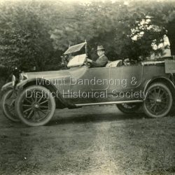 Jim Woolrich driving the Woolrich Service Car. Sign reads Sassafras - Olinda. Jim and his father George set up the car service in 1917 but it did not last long.: Jim Woolrich in their Touring Car.