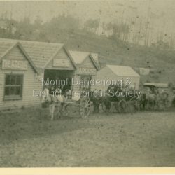 Hazy view of Jack Dodd's Store in Olinda's Main Street with carts in front c1909. Reverse of photograph has handwritten description by John Lundy-Clarke.: Dodds store Olinda 1905? With his butchers cutting cart leading the line of coaches in the Bayswater Sassafras Olinda run.