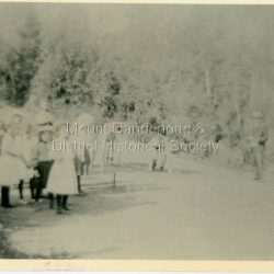 View of school children from Olinda State school at the Sports on Mernda (now Coonara) Road in 1909. The descriptive text on the reverse of this photograph was hand written by John Lundy-Clarke.: Olinda 1909 School sports on the (now) Coonara Road below the school.