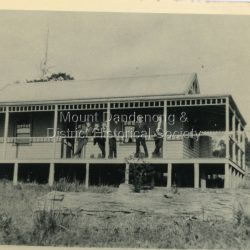 Dr Leonard Bell Cox (1894-1976) was a noted neurologist and collector. He had a family cottage 'Folly Farm' at Olinda, the garden of which had input from Edna Walling. He moved permanently to 'Folly Farm' in 1962. In his glasshouse, he propagated and cultivated rhododendrons and camellias, and gathered rare species. He helped to form the National Rhododendron Garden at Olinda, providing many specimens from his beautiful garden. This photograph showing a group of people on the balcony of 'Folly Farm' was taken in 1914 and the cottage looks to have been newly built. The descriptive text on the reverse of this photograph was hand written by John Lundy-Clarke.: Dr Coxs Folly Farm Falls Road Olinda. Lot 19 Section 3 Village Settlement. Taken 1914 copied 1974 by J.L.C.