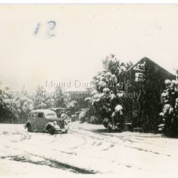 Car parked in an Olinda street during heavy snowfall. c1950
