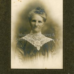 Studio photograph from Yeoman & Co. Royal Arcade, Melbourne. Portrait shows Emma Dorey (nee Biggin), grandmother of Iris Woolrich (nee Dorey) and mother to her father Edwin Charles Dorey. Emma is wearing a very intricate lace collar in the photograph. The photograph is framed in thick cardboard.: Handwritten on back: Emma Biggin Pitts. Dad's Mother. Granma Dorey.