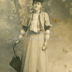 Studio portrait of well dressed young lady with parasol. Inscription on back indicates it is Netty Grossman. Photograph is in postcard format. Probably early 1900s.: Written on back in pen: Netty Grossman