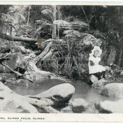 Young girl in a white pinafore and large, white hat sitting on a rock at the edge of Emerald Creek. Reverse of photograph has handwritten description by John Lundy-Clarke.: Emerald, Creek Emerald Creek with Jessie Wyles