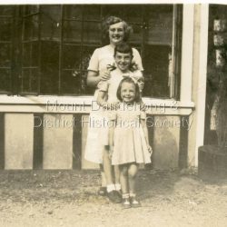 A woman with two young children posed outside the Quamby Café at Olinda c1950s. A woman with two young children posed outside the Quamby Café at Olinda c1950s.