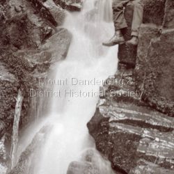 Man sitting on rock beside Olinda Falls.