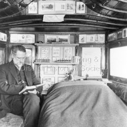View of John Garibaldi Roberts sitting, reading inside one of the old coaches at his country home Sunnyside in South Sassafras (now Kallista).