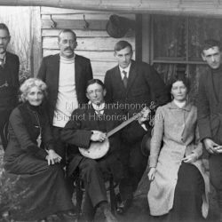 Group of people posed outside Sunnyside in South Sassafras (now Kallista).
Standing L to R: J G Roberts, Robert Croll, Harold B Herbert, Frank Roberts
Seated L to R: Roberta Roberts, C J Dennis holding banjo, Gwen Eastaugh (nee Roberts)