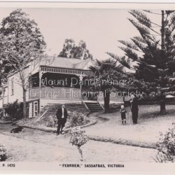 Fernhem Guest House situated in The Crescent at Sassafras. It is now a private home. An advert in the 1910 'Hotel and Boarding House Guide' states that: FERNHEM - Is beautifully situated amongst fernery glades and gladsome nature's sights. The accommodation offered is exceptional and the Proprietress with the greatest pleasure strives to make her guests during their stay, whether brief or lengthy, as happy and comfortable as human skill will allow. TERMS 30 /- PER WEEK. Milk and cream from our own cows. Correspondence invited. Mrs. TUTT, "Fernhem" SASSAFRAS.: B & W photograph from Rose Series postcard showing front view of Fernhem Guest House in sassafras. There are two men, a dog and a child in the foreground with a group of people on the verandah. A large tree is in the garden RHS.: The Rose Series # 1475 "FERNHEM' SASSAFRAS VICTORIA