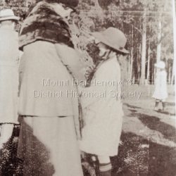 A smartly dressed lady speaking with a child during the visit of Edward, Prince of Wales to Sassafras in 1920.: Copy of a black and white photograph showing a close up picture of a well dressed lady talking to a child.